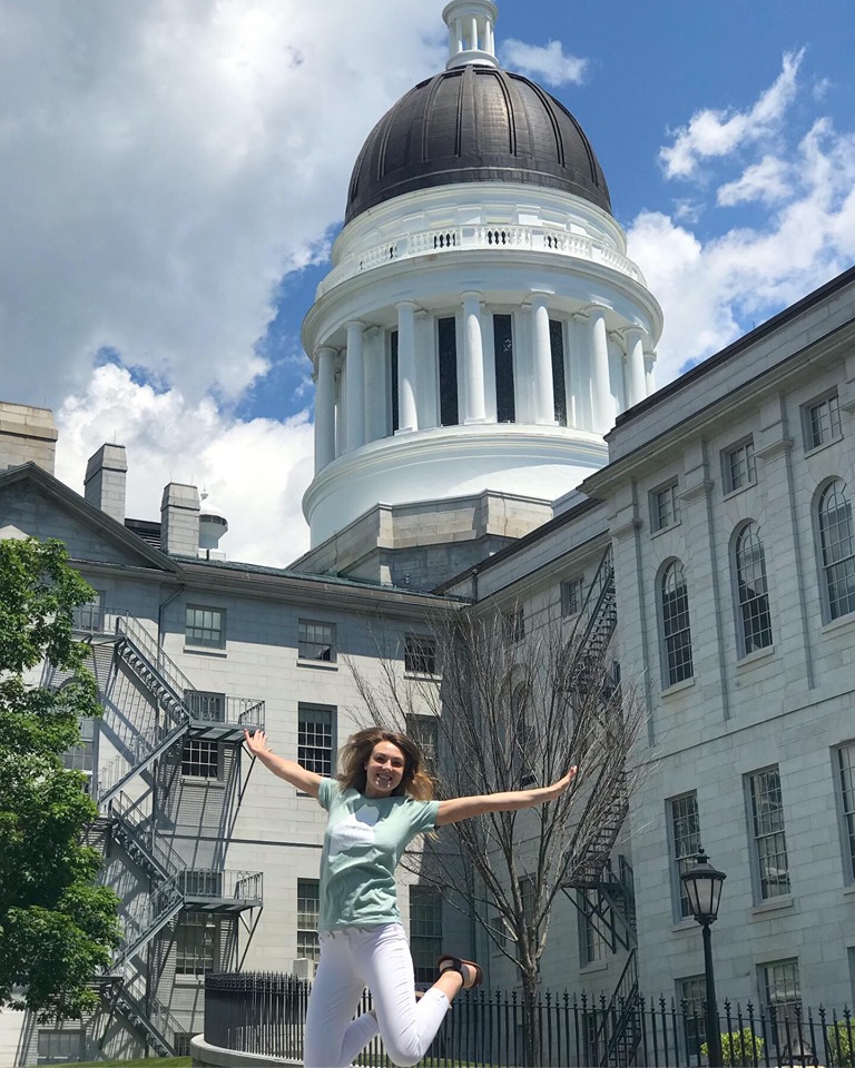 Image of Intern Jumping in Front of State House