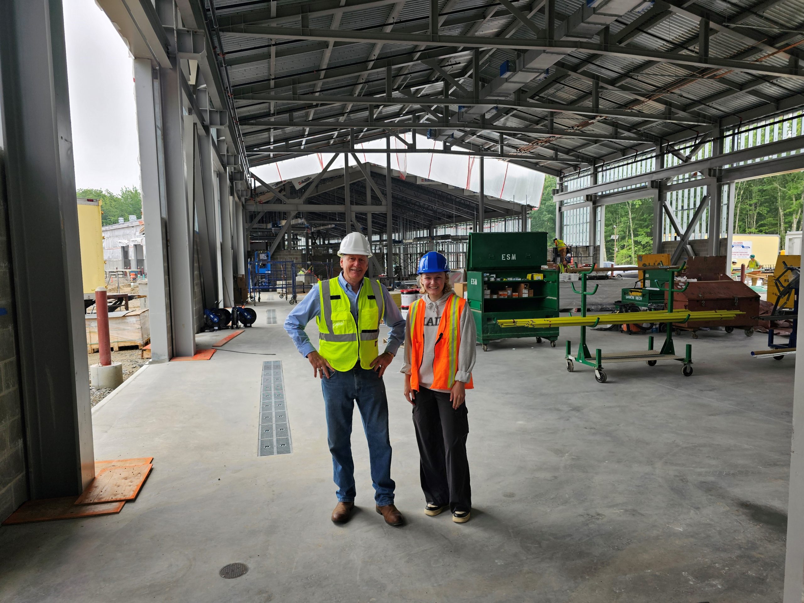 Two people wearing hard hats and reflective PPE