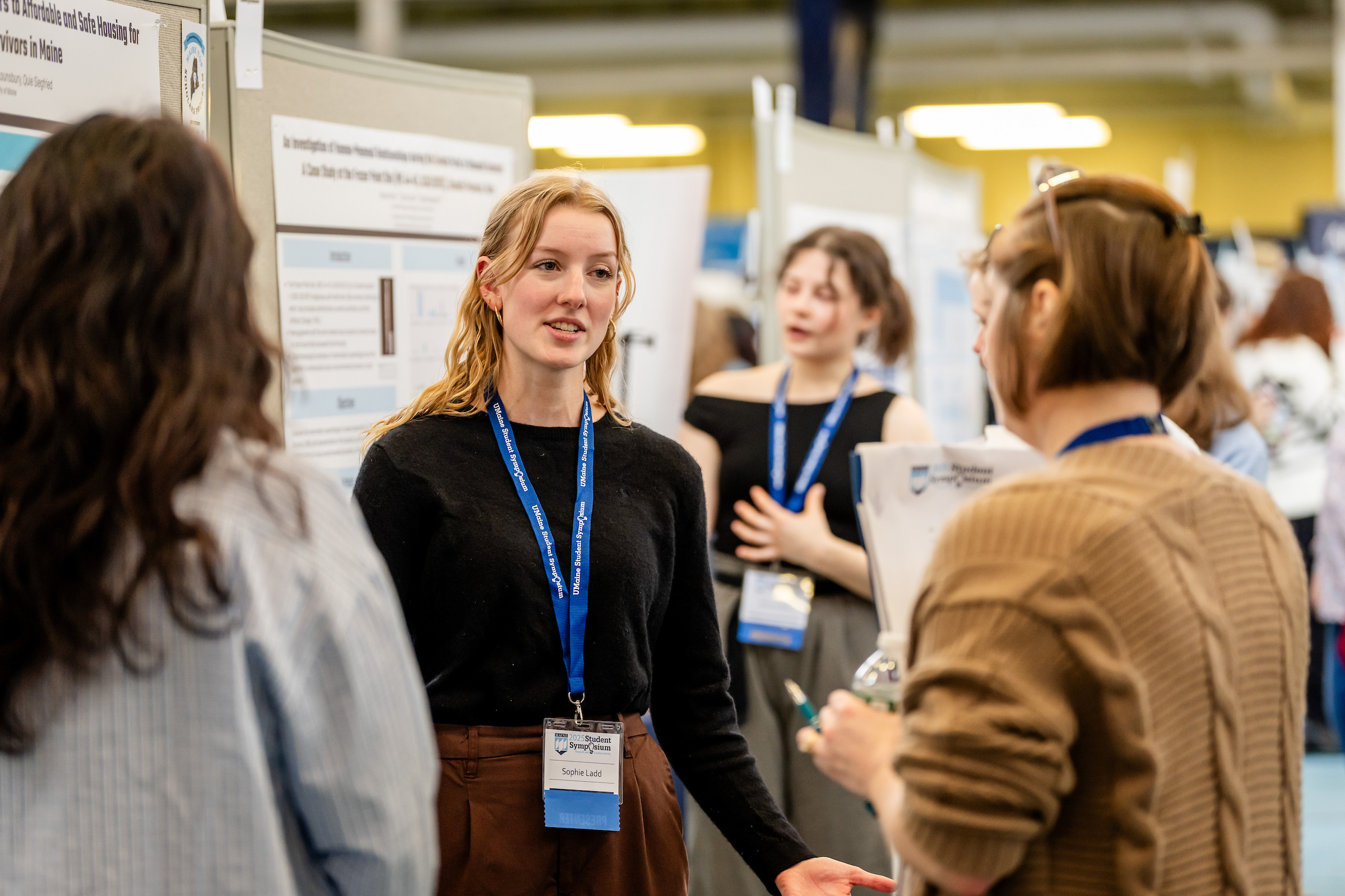 Student talks to conference attendees as she describes we research project.