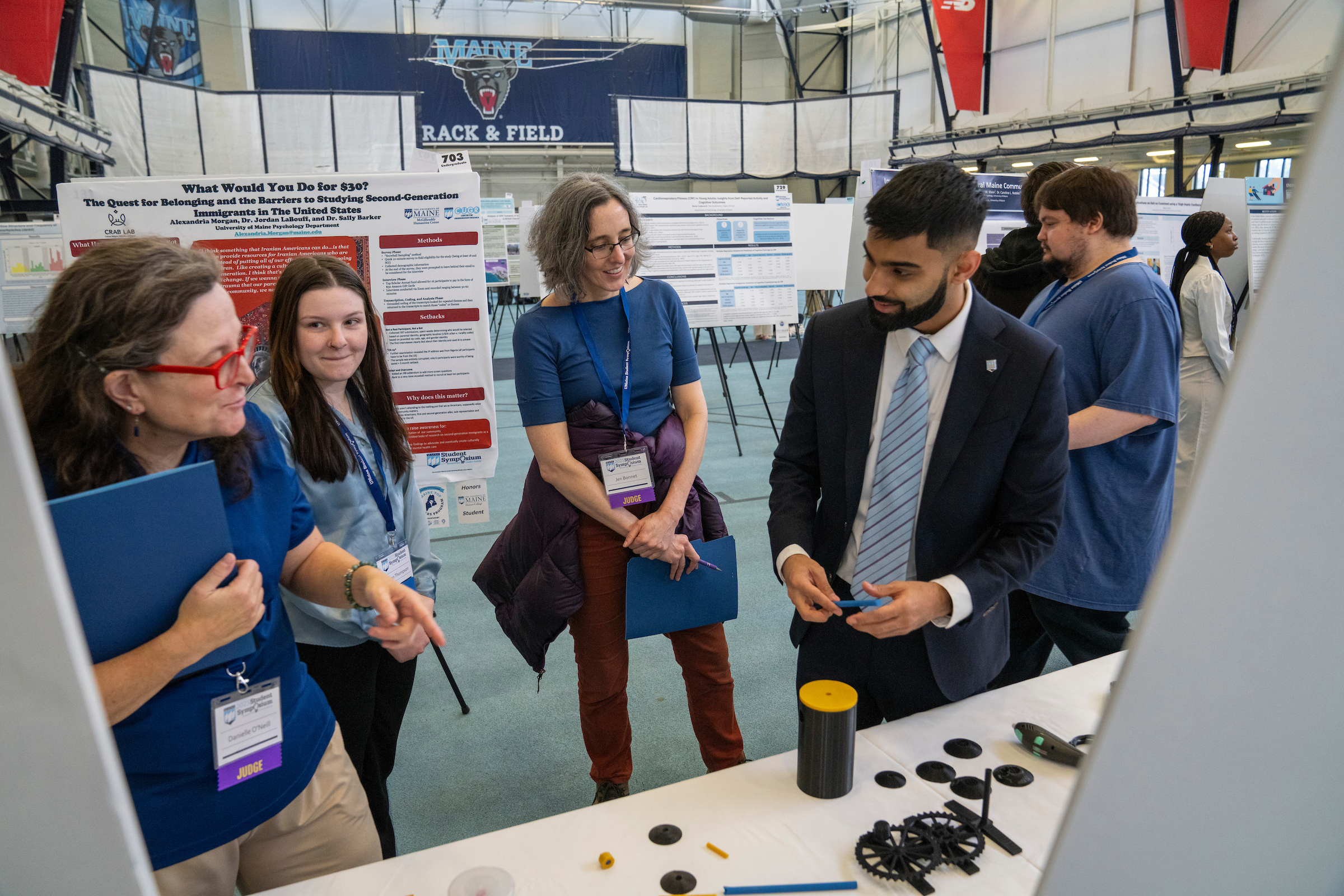 Student talks with conference attendees about his research project.